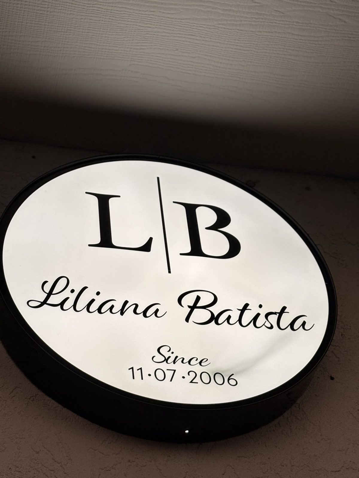 The round black and white sign inside the salon: L B, Liliana Batista, since 11·07·2006